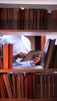A person is using a tablet computer in a library video