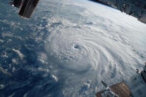 A dramatic view of a hurricane revealing its eye and swirling clouds as seen from above the Earth during daylight hours photo