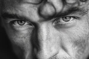 Close focus on a man's piercing gaze reveals deep emotions and thoughts in a dramatic black and white setting photo