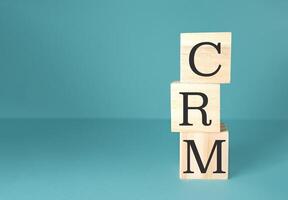 Stack of wooden blocks with the letters CRM on top photo
