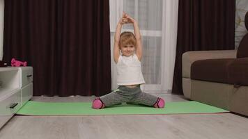 Child kid girl doing gymnastics fitness stretching workout at home. Fitness online program on laptop computer. Remote distance education, tutorial, training, family quarantine isolation. video