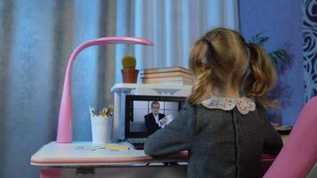 Child girl looking at web camera making call, learning geometric shapes at home. Online e-learning on internet, distance education with teacher. Lesson for children during coronavirus lockdown. video