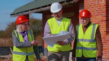 Architect with senior civil engineers discussing project work with blueprint of building house. Construction contractor working on a construction site of apartment. Discussing planning, development. video
