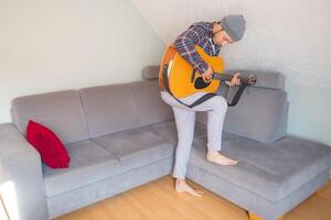 Close-up of guitarist in mid-performance at home photo