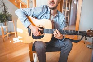 Sunlit room enjoys playing a beautiful wooden acoustic guitar and composing new songs. Immersed in the sweet tones of the guitar. Music that heals the soul photo