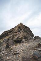 Jagged volcanic rock formation rises from Icelandic soil, sculpted by time and lava raw, ancient, and striking beneath a brooding sky photo