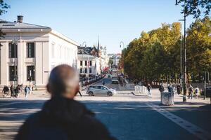 Crisp autumn day in central Oslo, where Karl Johans gate leads toward the Royal Palace, bustling with life, flags waving, and the city's charm on full display photo