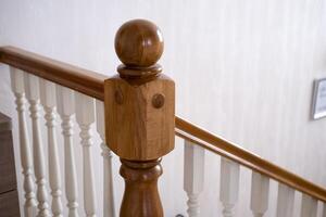 A wooden, staircase with a railing will lead to the top photo
