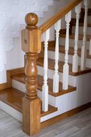 A wooden staircase, with a railing will lead to the top photo