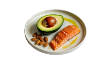 A plate with salmon fillet, avocado half, and almonds, drizzled with oil, on a light surface on transparent background png