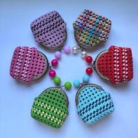 A circle of colorful crocheted purses arranged in a circle photo