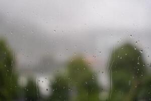 Raindrops on window with blurred view of trees and overcast sky in Bergen, Norway. photo