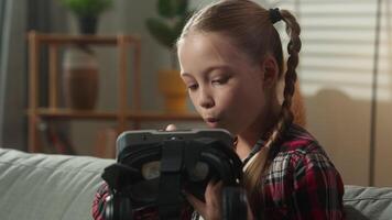Excited Caucasian little girl child kid daughter exploring virtual reality headset amazed by reflection waving hello smiling discovering immersive digital vr futuristic technology innovation at home video