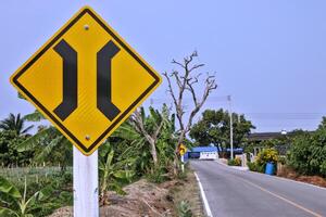 The sign warns of a narrow bridge to slow down the vehicle and beware of the dangers of a vehicle that will run in opposite directions photo