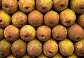A close up view of a stack of pears showing their color and texture in an organized presentation photo
