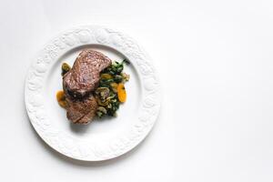 Steak with vegetables on a white plate on a white background in a minimalist style photography photo