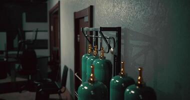 CGI Green gas cylinders lined up in a dimly lit industrial workspace video