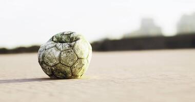 CGI Weathered soccer ball resting on sandy beach during sunset video