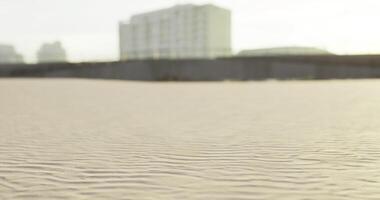 CGI Sand patterns on a beach with buildings in the background at sunset video