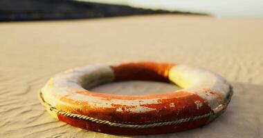 CGI Lifebuoy resting on the sandy shore at sunset near the ocean video