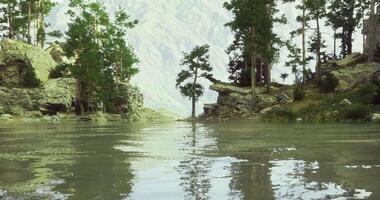 CGI Tranquil lake surrounded by lush trees and mountain scenery during daylight video