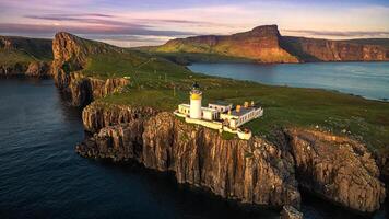 Aerial view of neist point lighthouse on the isle of skye scotland at sunset with rocky cliffs and ocean photo