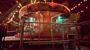 The concept of CGI Empty amusement park at night with illuminated carousel and festive lights video