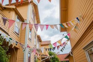 A row of colorful bunting hanging from the side of a building photo