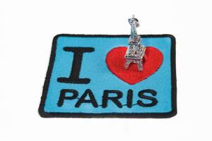 Embroidered message I LOVE PARIS with a red heart and small Eiffel Tower placed on top. Isolated on white, perfect for romantic travel and Paris themes. photo