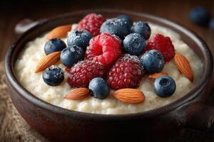 Bowl of creamy oatmeal topped with vibrant raspberries, blueberries, and almonds, showcasing a nutritious breakfast option photo