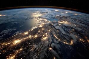 An aerial perspective of Earth at night reveals sparkling city lights over land and shimmering water against a dark backdrop of space photo