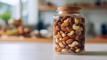 Glass jar filled with assorted nuts sits on a kitchen counter bathed in natural light. photo