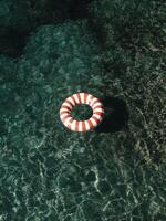 Floating Lifebuoy in Clear Turquoise Water on Sunny Day. photo