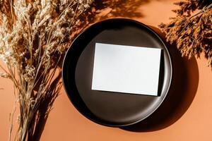 Elegant Arrangement of Blank Card, Dried Flowers, and Dark Cup on Rustic Table. photo