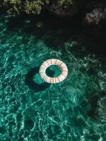 Lifesaver Ring Floating in Clear Swimming Pool Water on a Sunny Day. photo