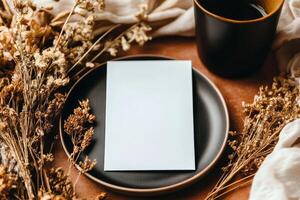Elegant Arrangement of Blank Card, Dried Flowers, and Dark Cup on Rustic Table photo