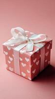 Gift Box Wrapped in Pink Paper With Heart Patterns Perfect for Celebrations and Special Occasions. photo