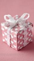 Gift Box Wrapped in Pink Paper With Heart Patterns Perfect for Celebrations and Special Occasions photo