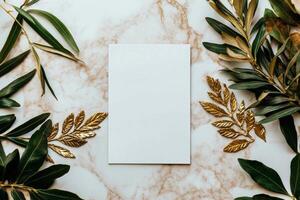 Elegant Blank Card Surrounded by Green and Gold Leaves on a Marble Surface photo