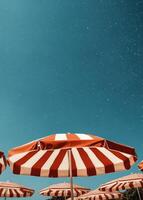 Bright Summer Afternoon With Striped Umbrellas Under Clear Blue Sky photo