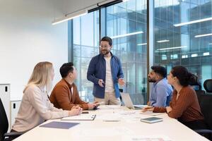 A diverse team collaborates in a modern office setting during a business meeting. They are discussing a plan. photo