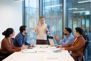A diverse team collaborates in a modern office meeting room, discussing ideas around a large table during a business presentation. photo