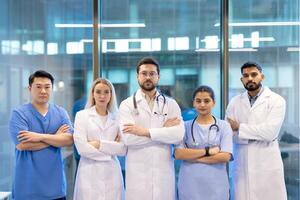 A diverse medical team stands together, arms crossed, conveying unity and expertise in a modern healthcare setting. photo