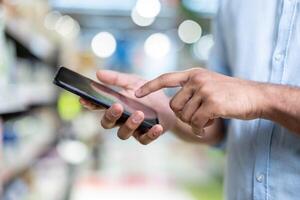 A person's hands are using a smartphone, possibly in a store. The image is well-lit and the focus is on the phone. photo