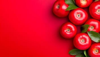 Fresh red apples on a vibrant background. Bright red apples with green leaves arranged against a striking red backdrop create an appealing visual display. photo