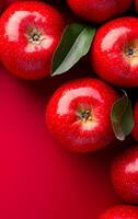 Fresh red apples on a vibrant background. Bright red apples and green leaves are neatly arranged against a vivid red background for an appealing display. photo