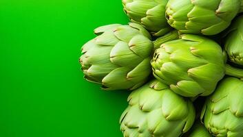 Artichokes on green backdrop. Fresh green artichokes are displayed on a vibrant green background, showcasing their unique shape and color. photo