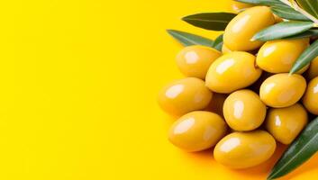 Fresh yellow olives on bright background. Yellow olives and green leaves pop against a bright yellow backdrop, highlighting their vibrant color and freshness. photo