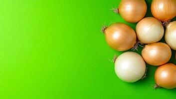 Fresh onions on bright green surface. Various types of onions arranged on a vibrant green background, showcasing their different sizes and shapes. photo