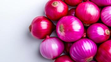 Vibrant onions on display. A mix of vibrant red and purple onions arranged neatly on a light surface, emphasizing their natural sheen and texture. photo